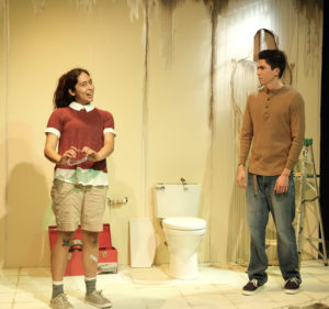Girl and her brother are shown speaking in a damaged bathroom.