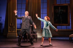 Warbucks and Annie dance together onstage.